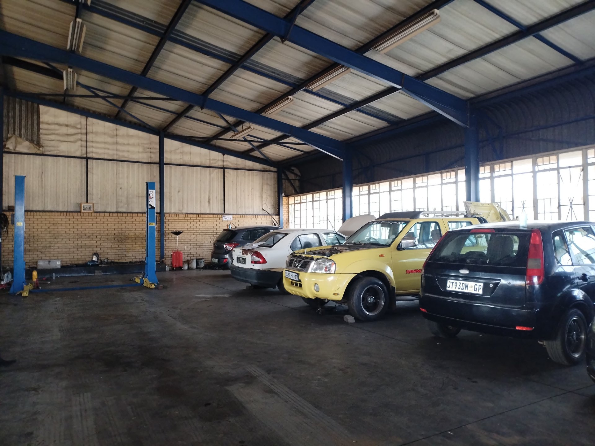 Two-post hydraulic lift bay inside the workshop